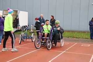 people using inclusive bikes on athletics track