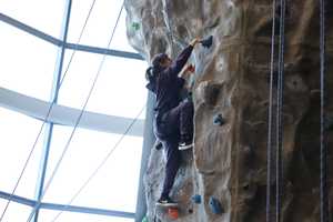 Girl climbing on indoor climbing wall.