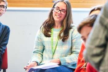A student smiles during an interactive seminar, representing the collaborative learning environment for Norwich students.
