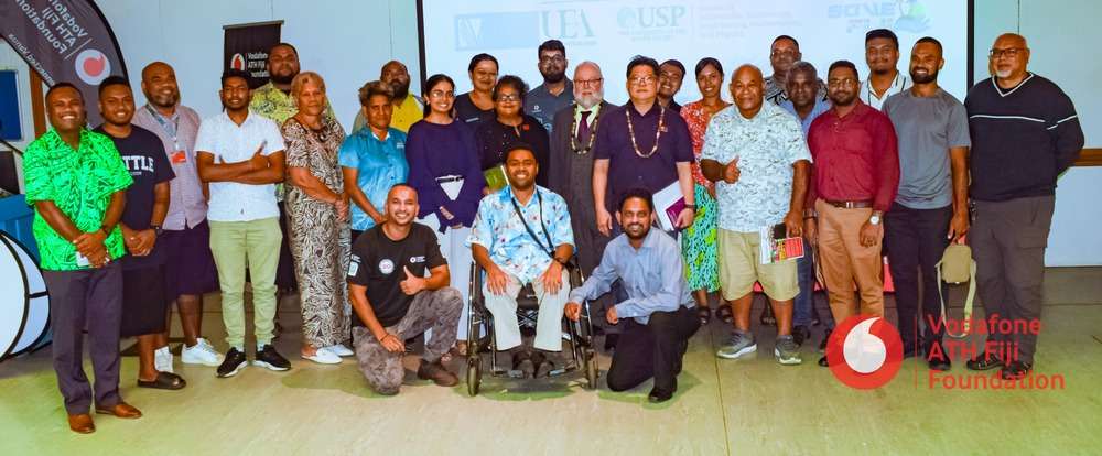 Large, smiling group of people at conference in Fiji sponsored by Vodafone