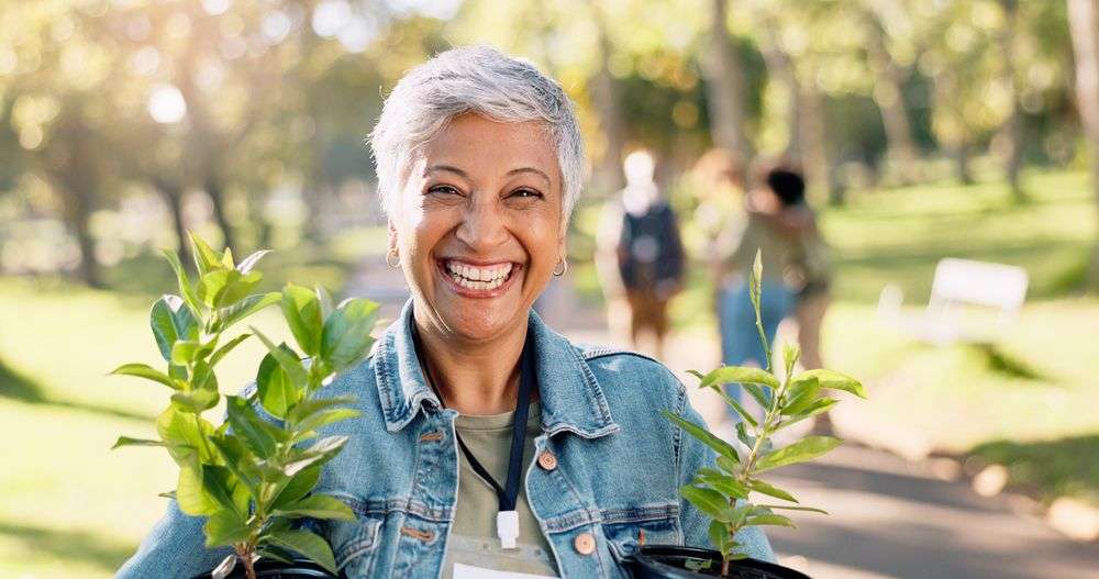 smiling elderly woman holding plants