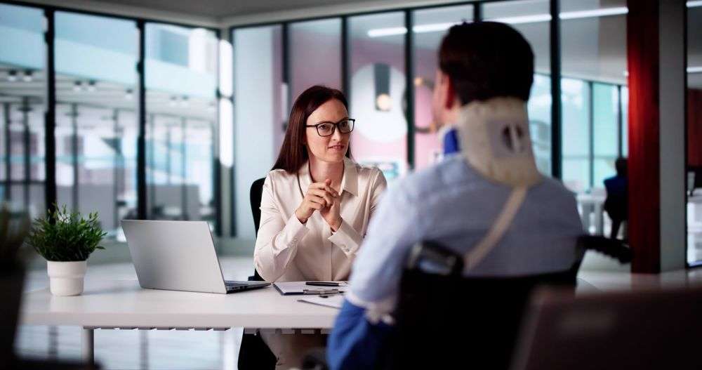 woman at a desk advising injured man