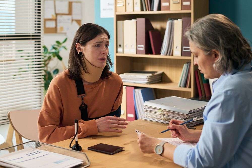 injured woman talking to someone at a desk