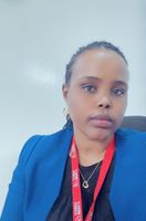 Person wearing a blue blazer and red lanyard, seated against a light background, looking at the camera with a neutral expression.
