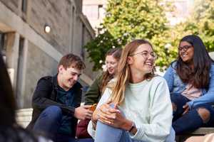Students sitting on steps in the square