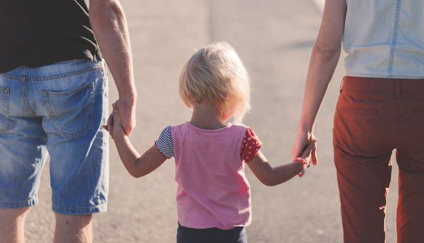 Parents walking with child hand in hand