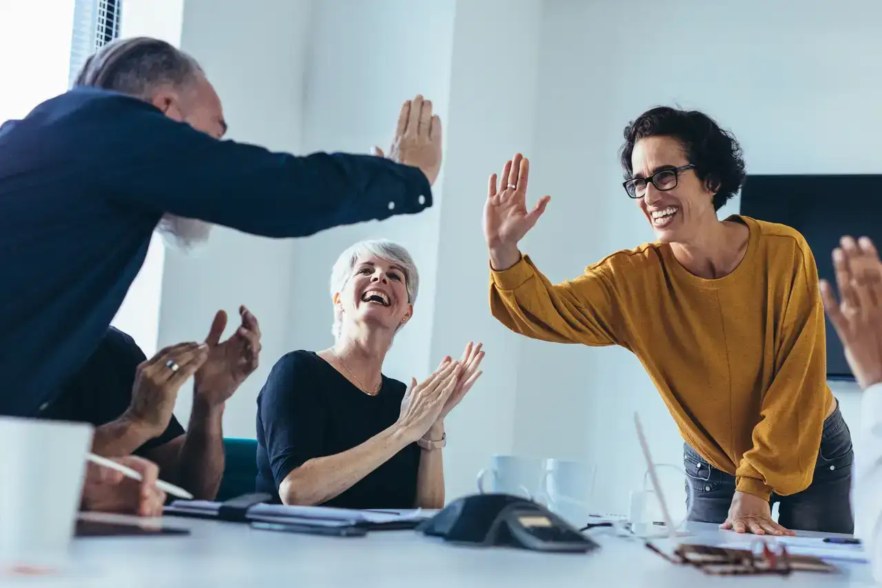 People high fiving at a table