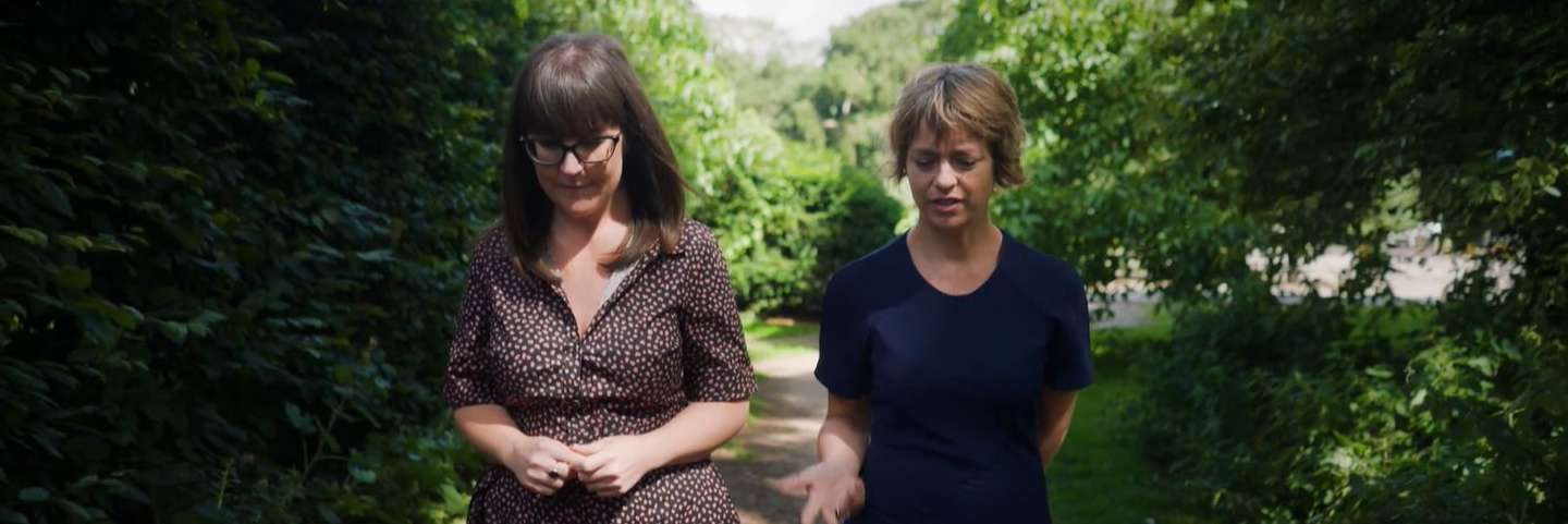 Caitlin Notley and Nicola Robinson walking down a leafy path.