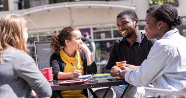 students talking around table