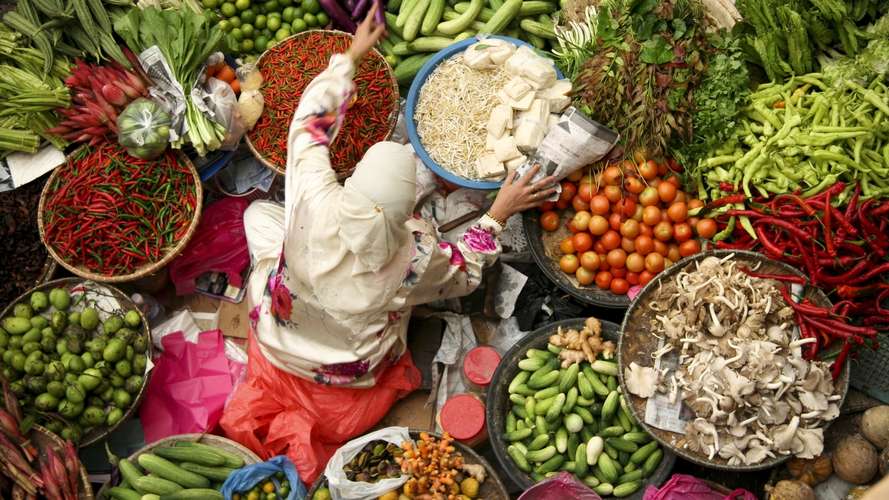 asian woman at fresh vegetables and spices market