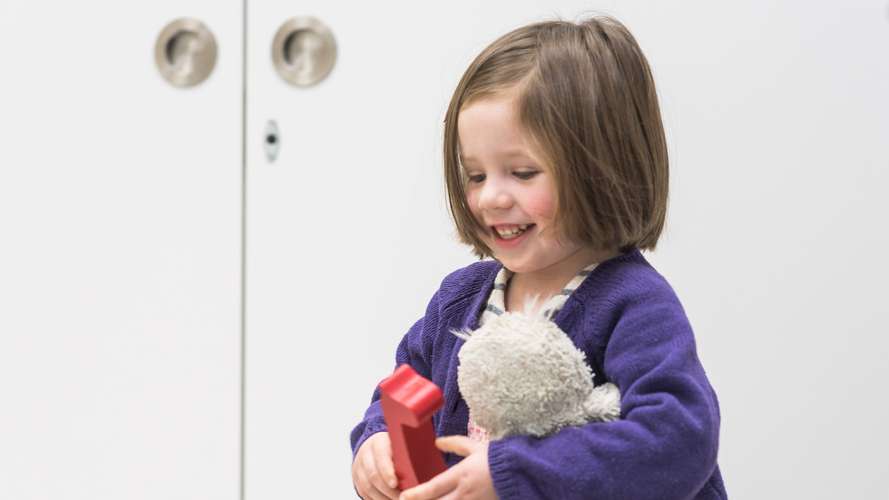 child holding toys smiling