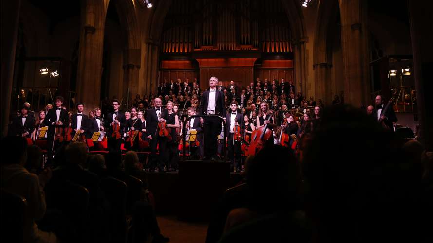 Orchestra standing before audience at UEA Music Centre performance