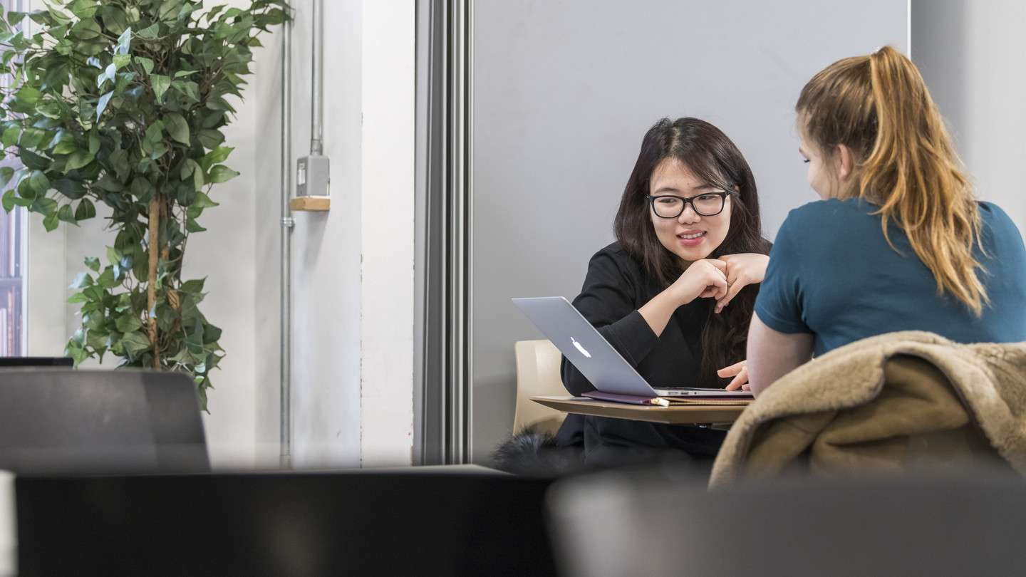 two students sat around laptop
