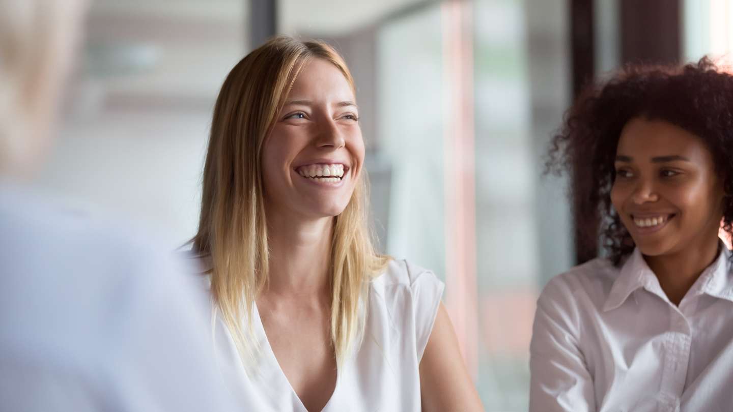 women smiling in business meeting