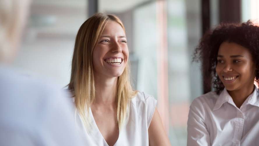 women smiling in business meeting