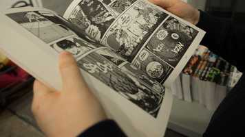 Person holding open a comic book