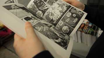 Person holding open a comic book