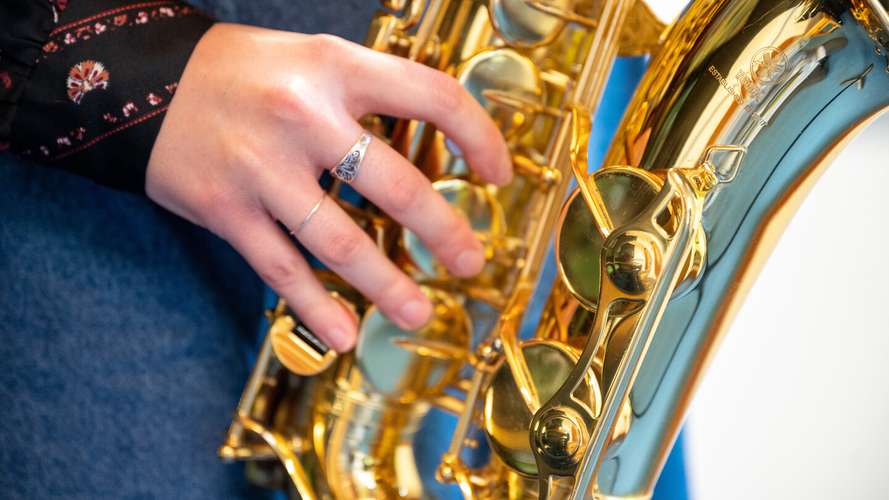 A music student playing saxophone in a practice room at the Music Centre, UEA.