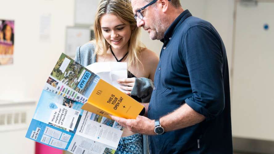 parent and a student looking at a leaflet at an open day
