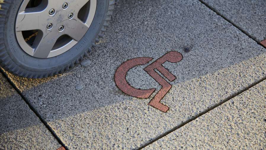 wheel next to wheelchair symbol on ground