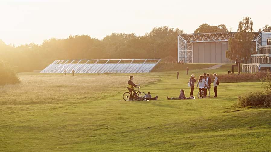 Students sitting by the Ziggurats accommodation on campus.