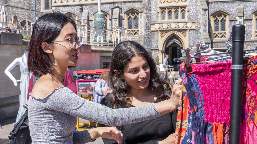 Four students walking through Norwich market