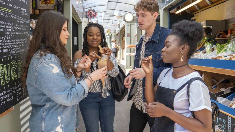 students eating food at Norwich market