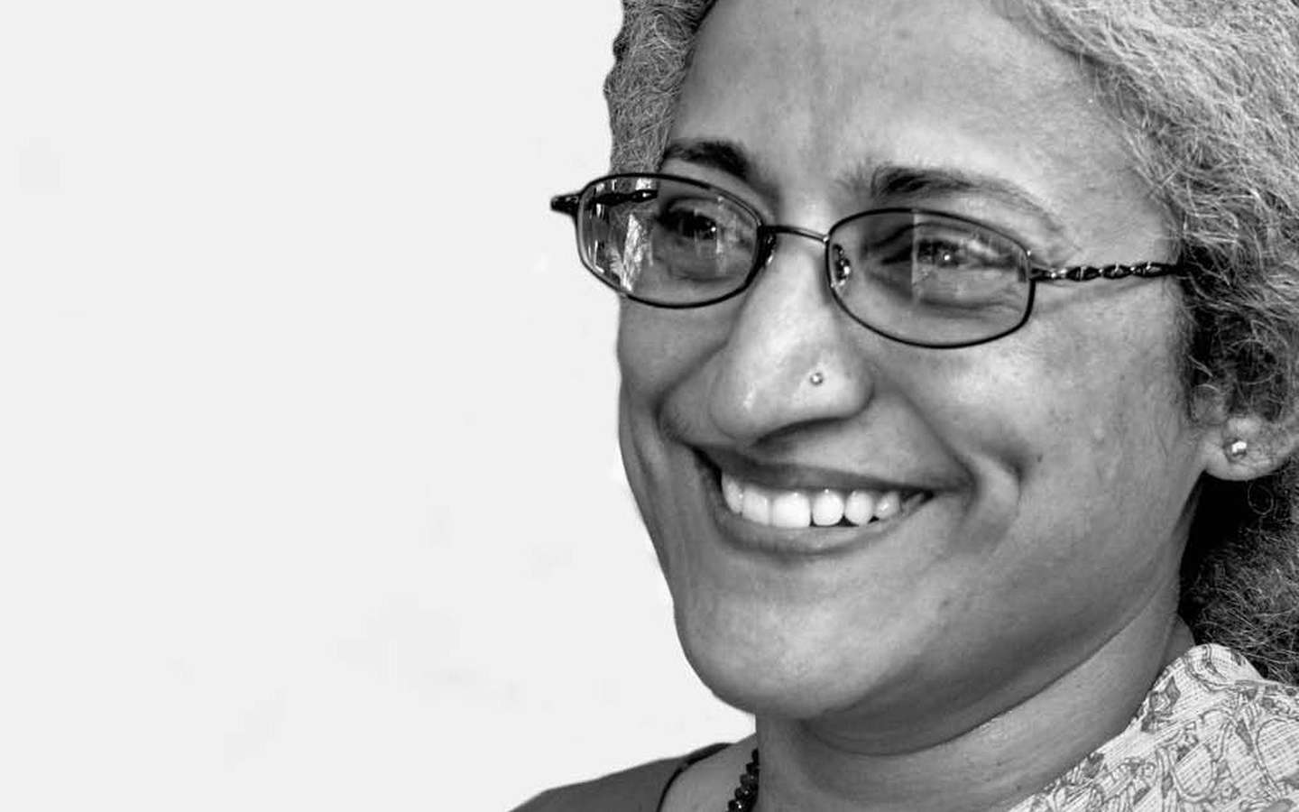 A black and white photo of a woman smiling.