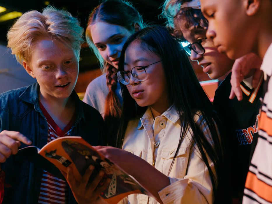 adolescents gathered around a magazine
