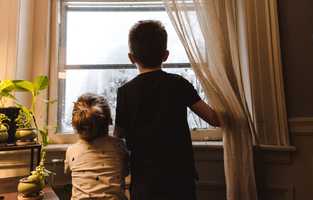 Boy and Girl looking out of a window