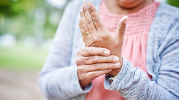 Person holding their wrist