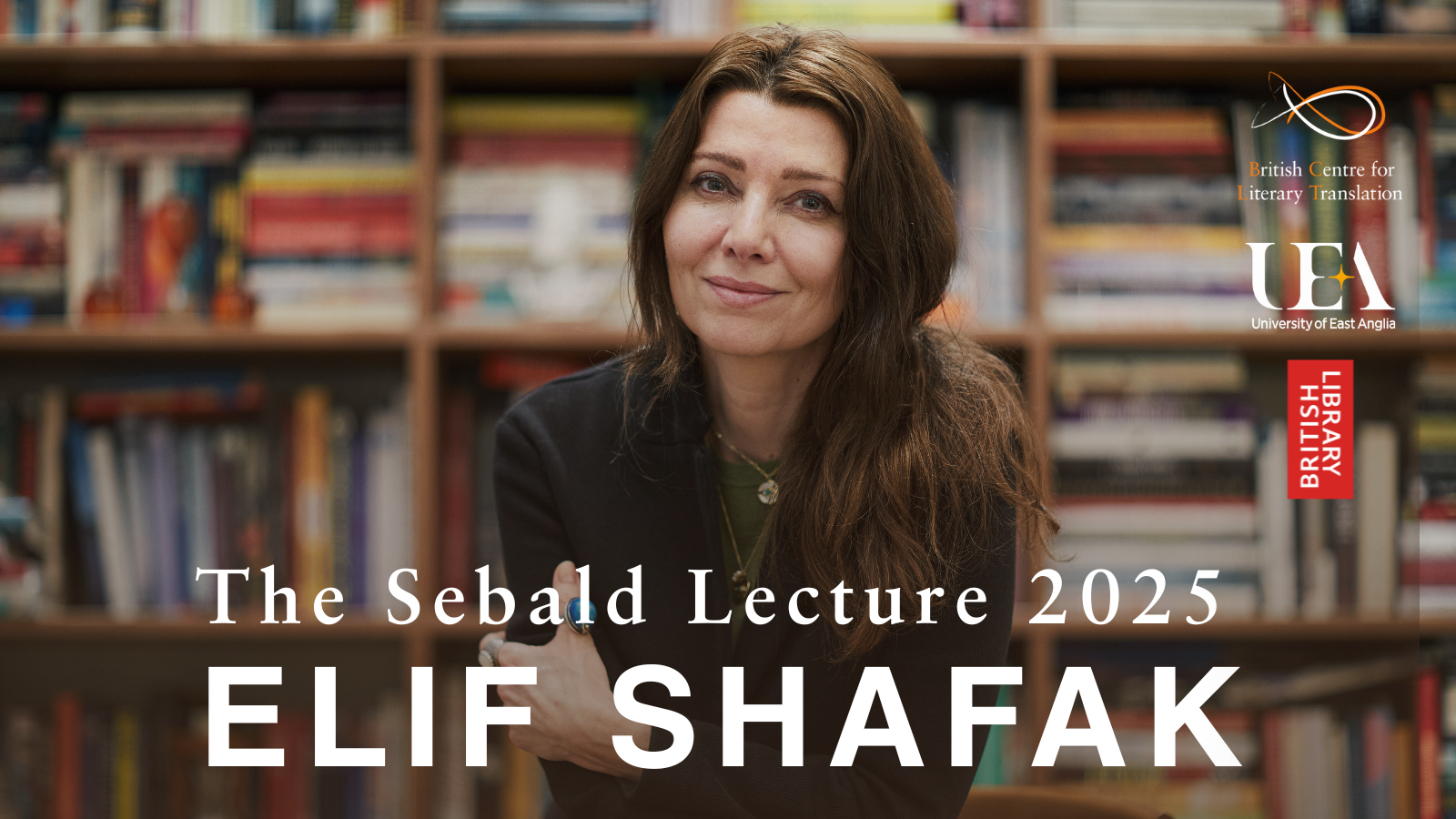 This image shows Elif Shafak infront of a bookshelf. Elif has long dark hair