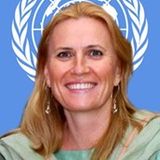 Dr. Monika Oledzka-Nielsen, in front of the UN logo