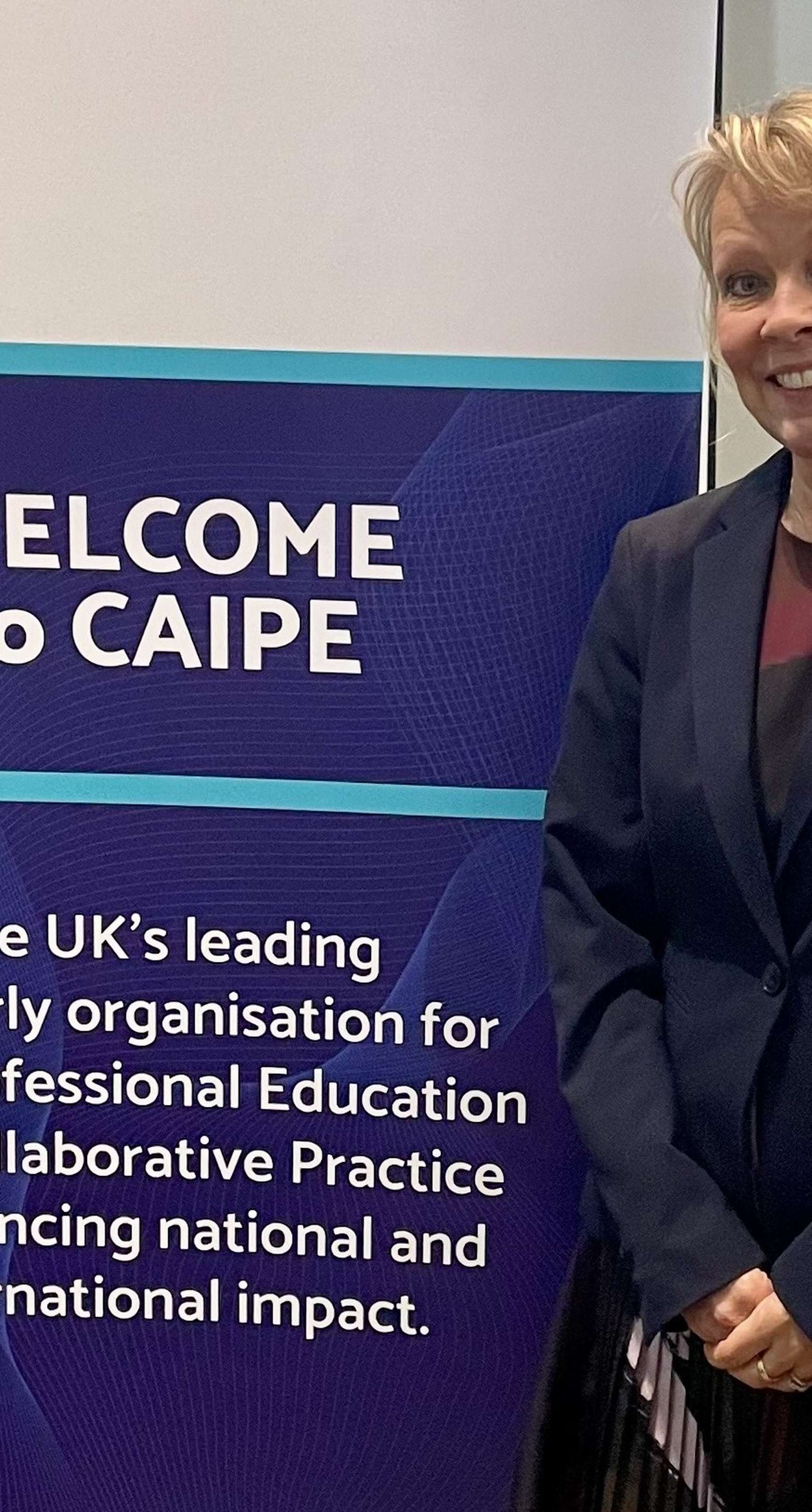 Image of Suzanne standing next to a pop up sign