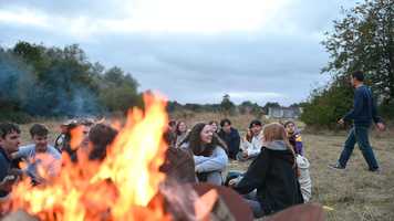 People sitting and chatting around a firepit.