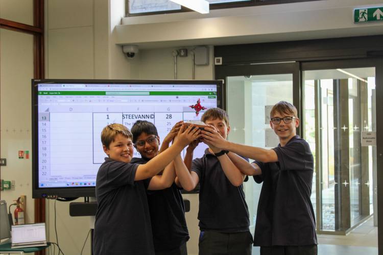 Four students from Diss High School lift the ScrapBot Olympics 2023 trophy.