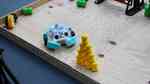 A ScrapBot made of a clear plastic mixing bowl navigates the assault course.