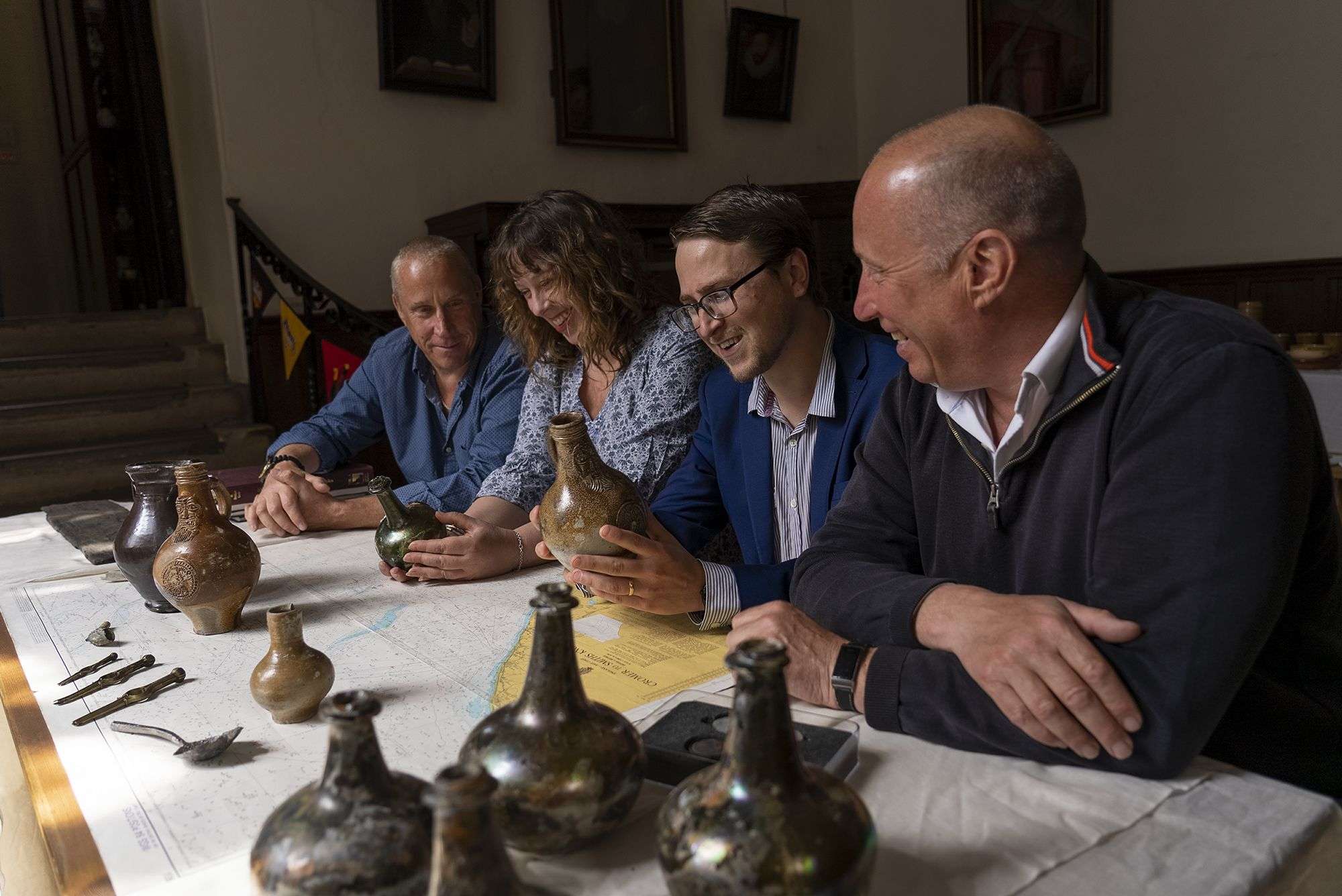 L–R: Lincoln Barnwell, Prof Claire Jowitt, Dr Benjamin Redding, and Julian Barnwell are examining a vase.