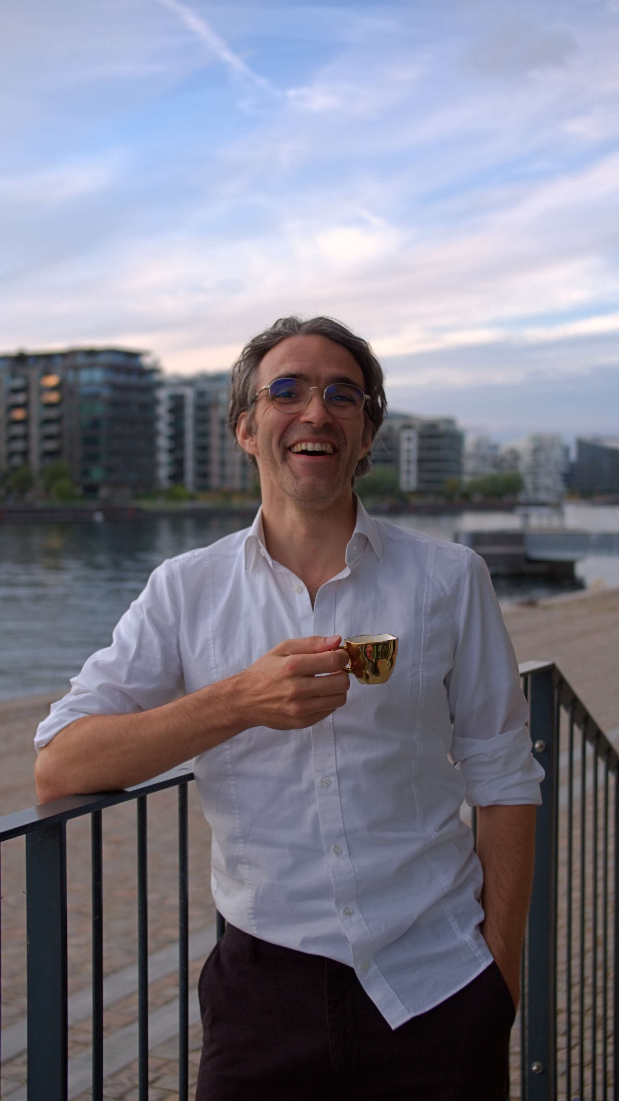 A photo of someone drinking a coffee and smiling.