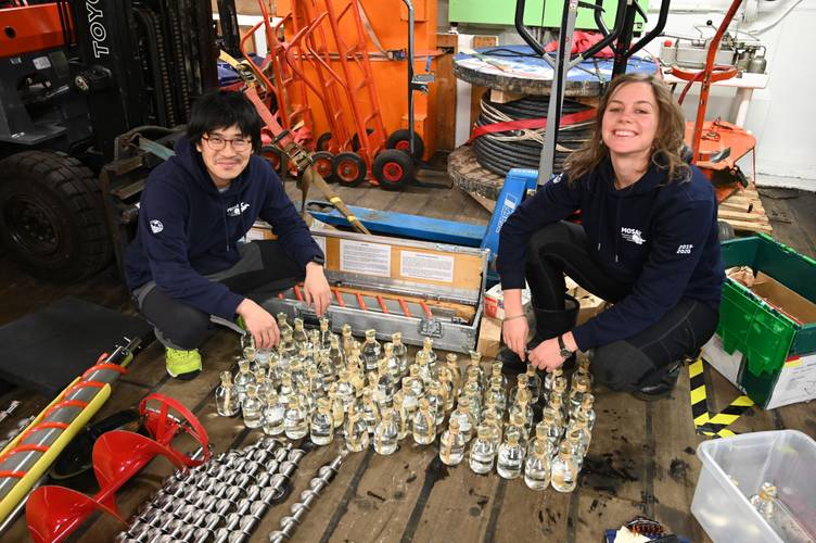 Two scientists conducting analysis on bottles of seawater
