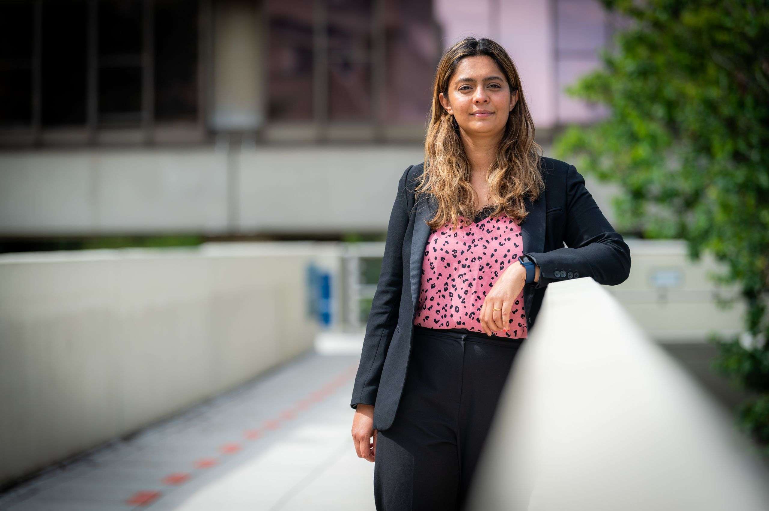 A person looking into the camera with building background