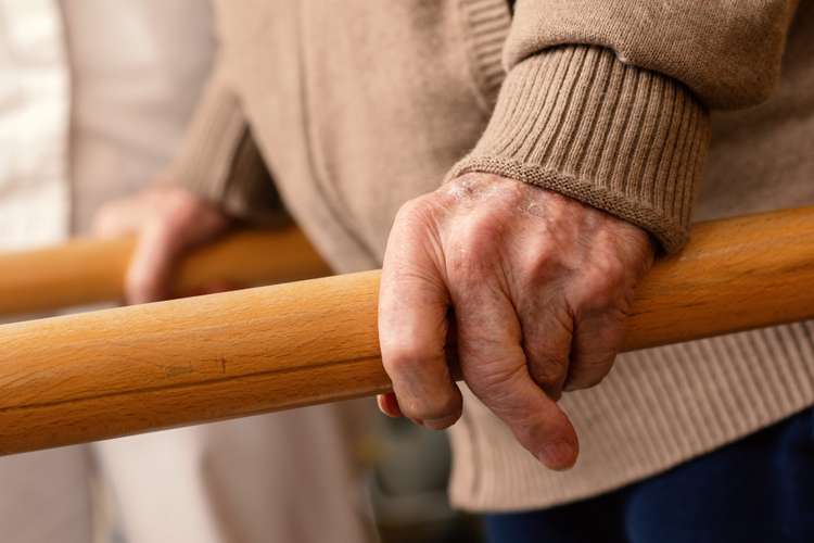 Elderly hands using a rail for support