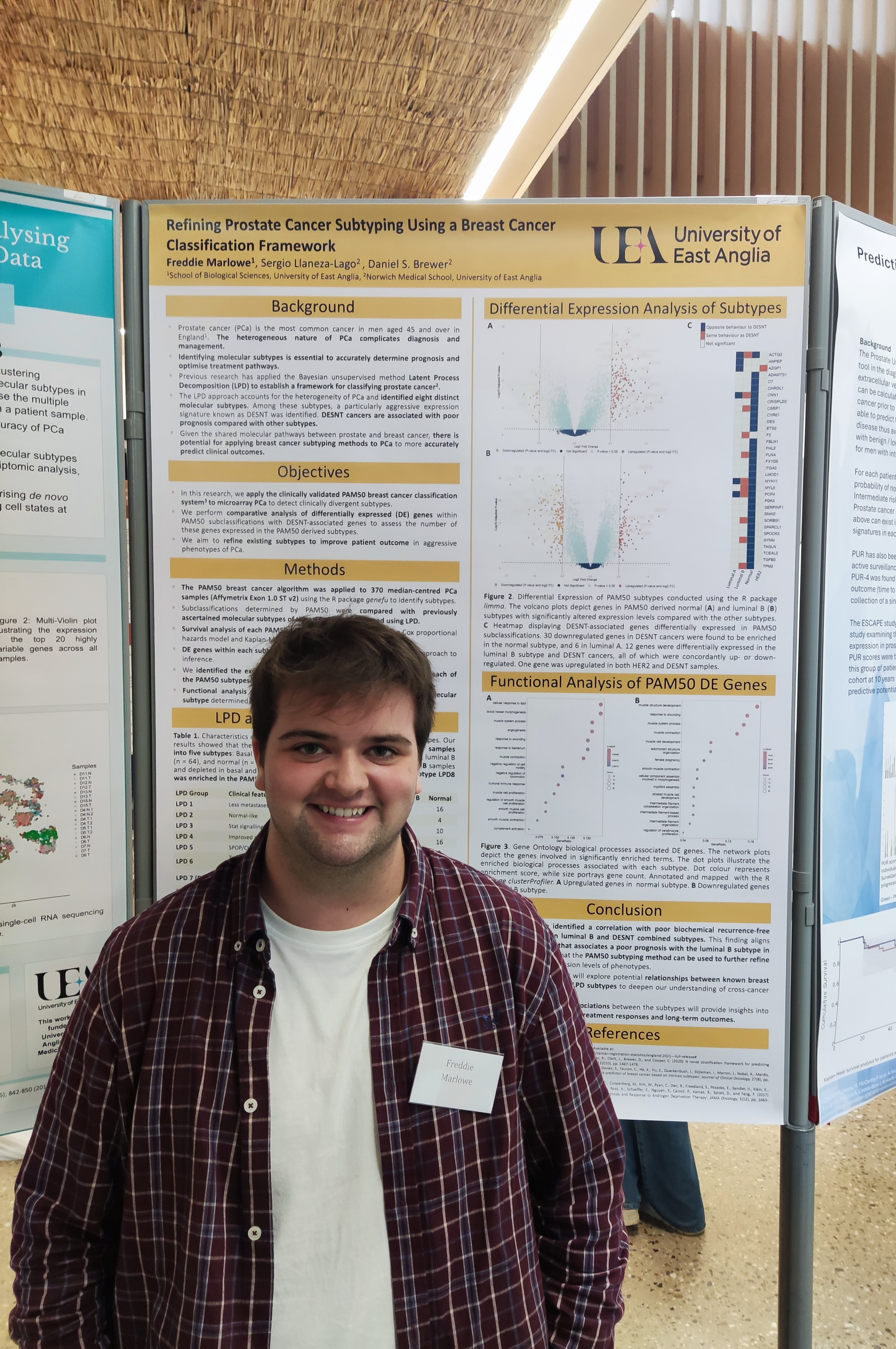 Freddie stands in front of a poster, showcasing his summer placement focused on cancer genetics and prostate cancer research.