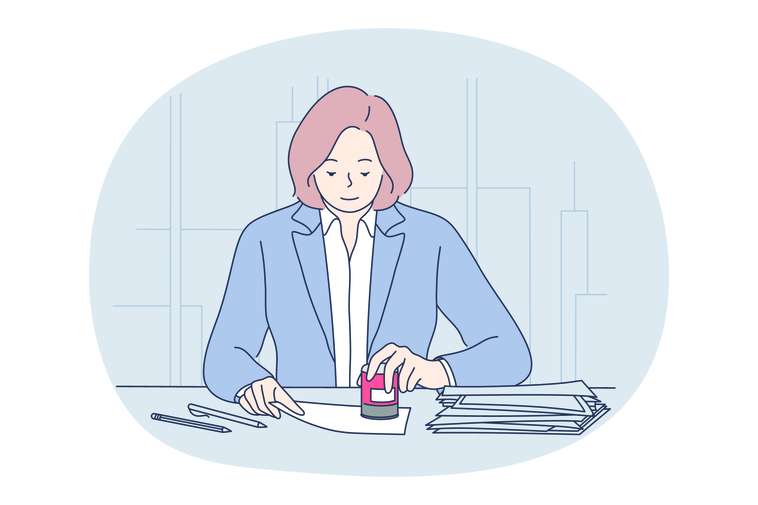 woman at a desk with paper, pens, and stamp