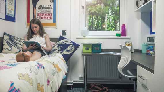 A girl reading her notes on her bed