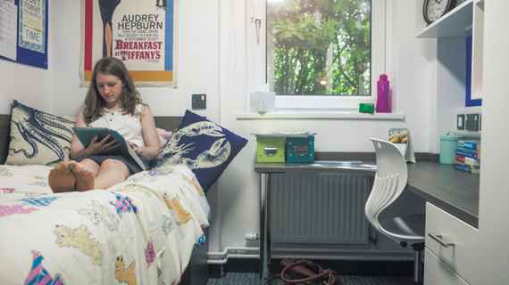 A girl reading her notes on her bed