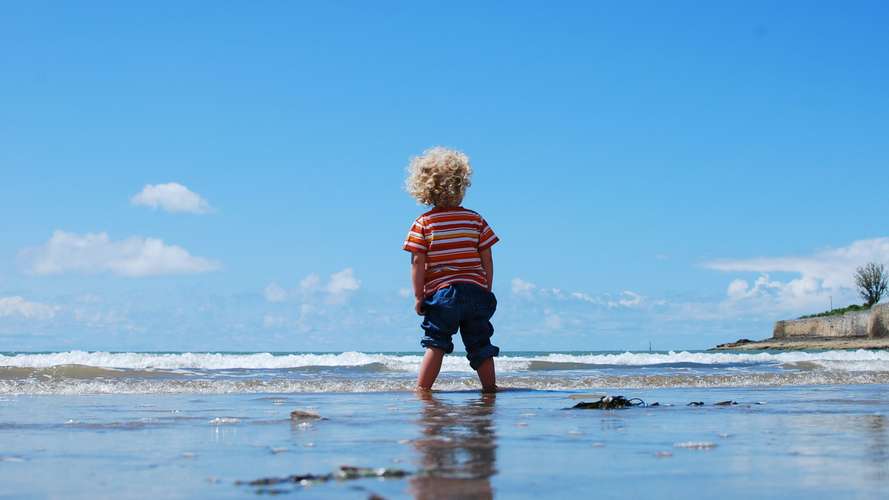 child paddling on beach