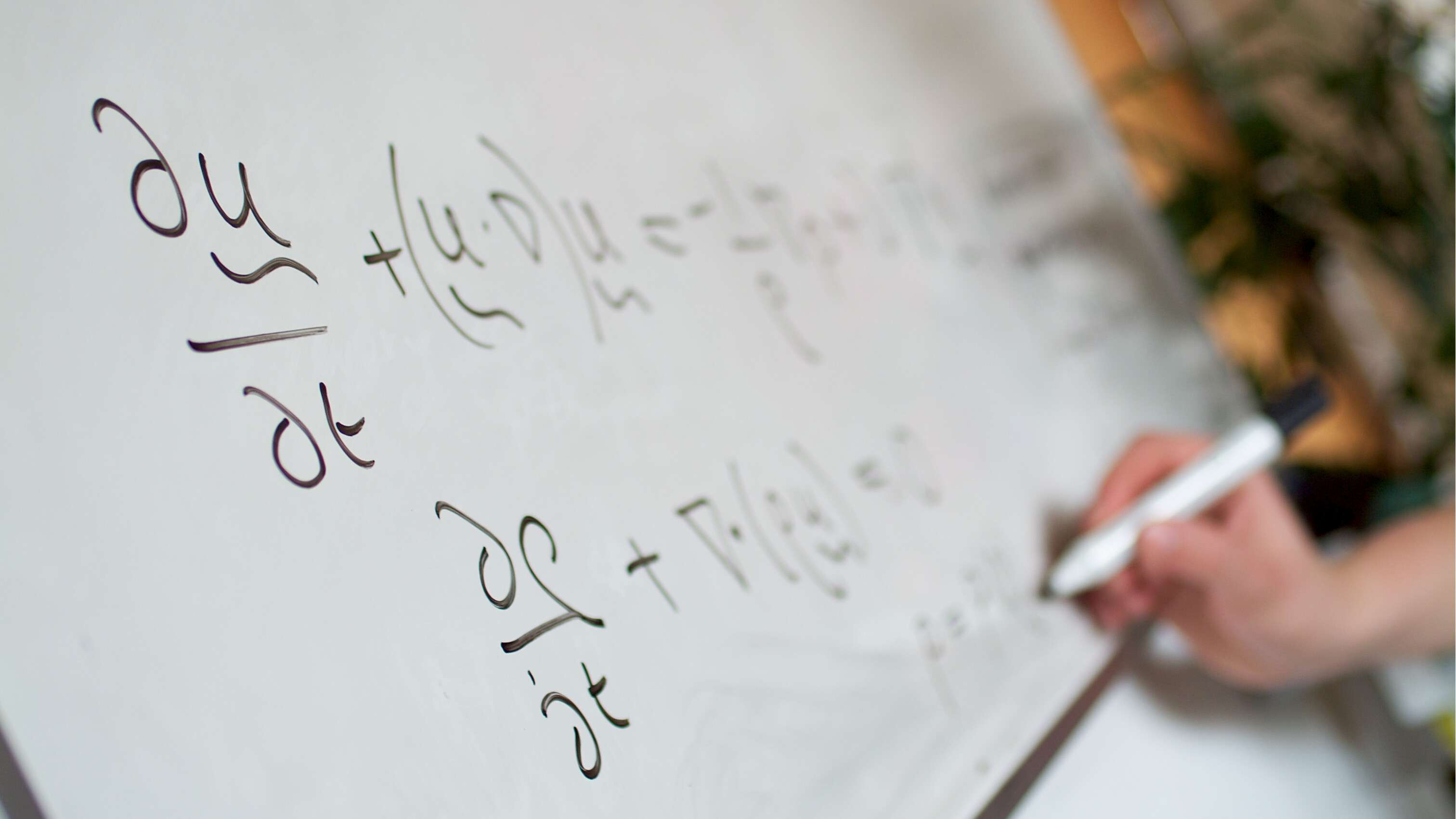 MTH Students writing mathematical sums on a whiteboard.