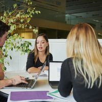 mature students collaborating sat around table with laptops