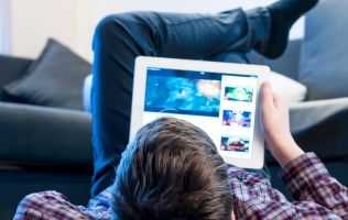 Image of someone looking at an iPad while laying on their back
